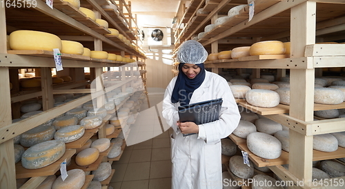 Image of African black muslim business woman in local cheese production company