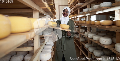 Image of African black muslim business woman in local cheese production company