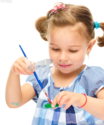 Image of Little girl is painting with gouache