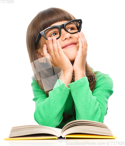 Image of Young girl is daydreaming while reading book