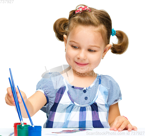 Image of Little girl is painting with gouache