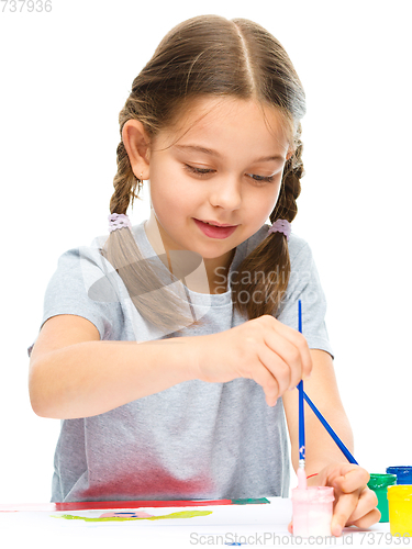 Image of Little girl is painting with gouache