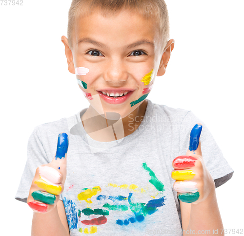 Image of Portrait of a cute boy playing with paints