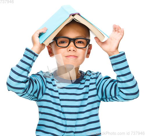 Image of Little boy plays with book