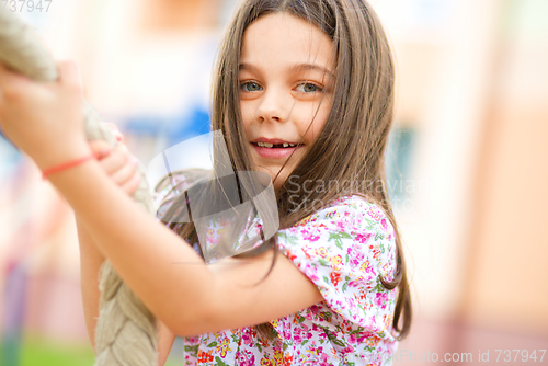 Image of Cute little girl is playing in playground