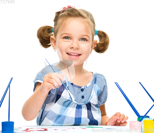 Image of Little girl is painting with gouache