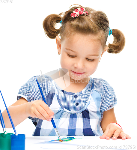 Image of Little girl is painting with gouache