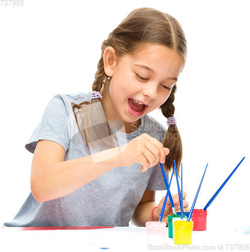 Image of Little girl is painting with gouache