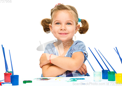 Image of Little girl is painting with gouache