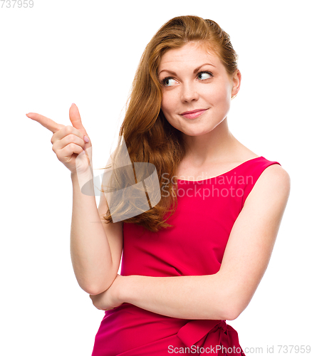 Image of Portrait of a young woman pointing to the left