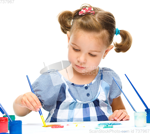 Image of Little girl is painting with gouache