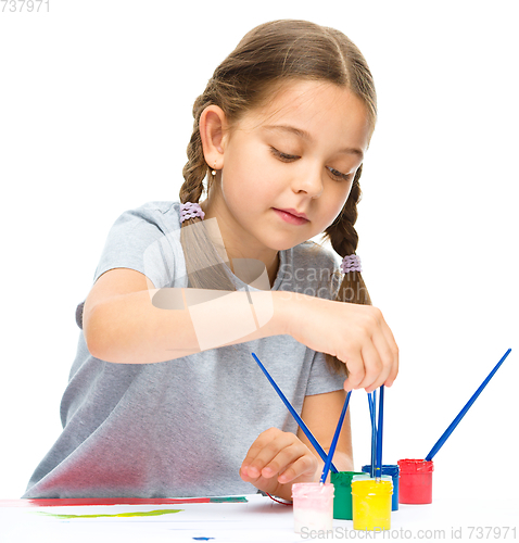 Image of Little girl is painting with gouache