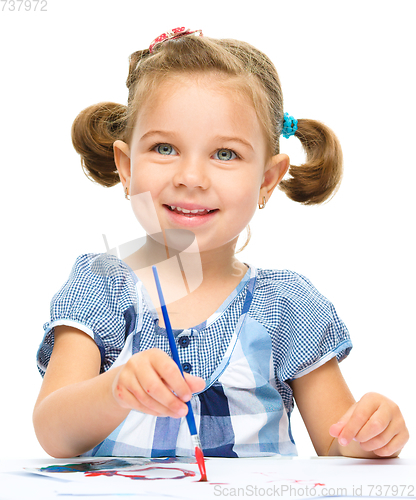 Image of Little girl is painting with gouache