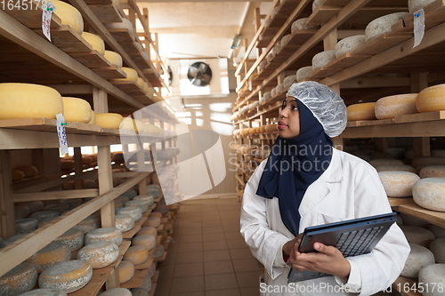 Image of African black muslim business woman in local cheese production company