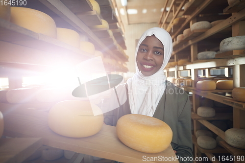 Image of African black muslim business woman in local cheese production company