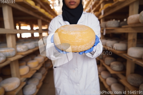 Image of African black muslim business woman in local cheese production company