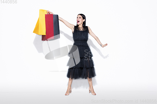 Image of Young woman in dress shopping on white background