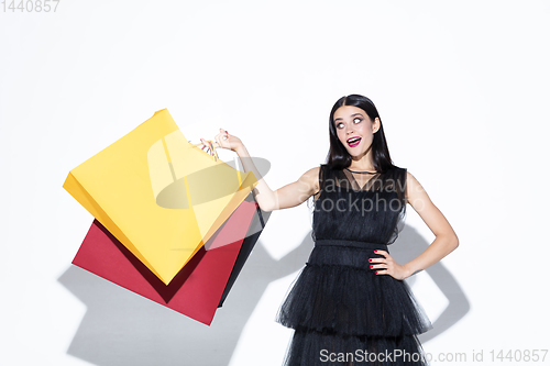 Image of Young woman in dress shopping on white background