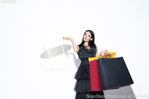 Image of Young woman in dress shopping on white background