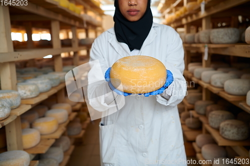 Image of African black muslim business woman in local cheese production company