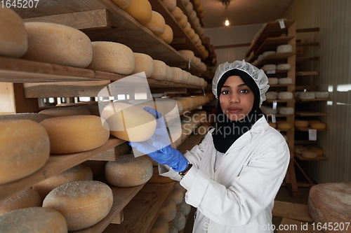 Image of African black muslim business woman in local cheese production company