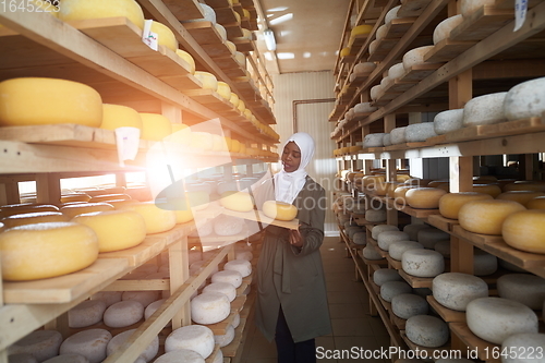 Image of African black muslim business woman in local cheese production company