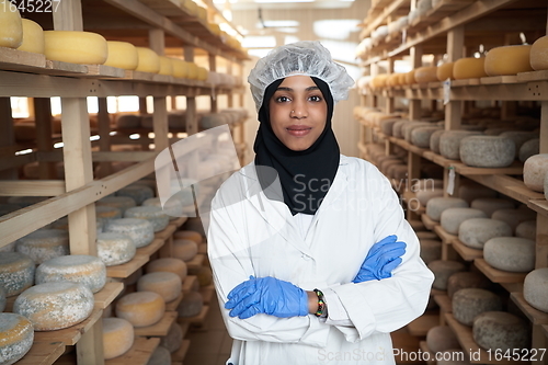 Image of African black muslim business woman in local cheese production company