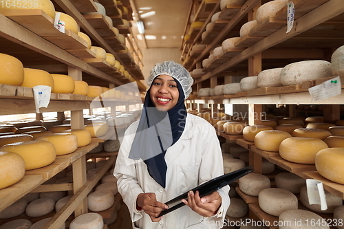 Image of African black muslim business woman in local cheese production company