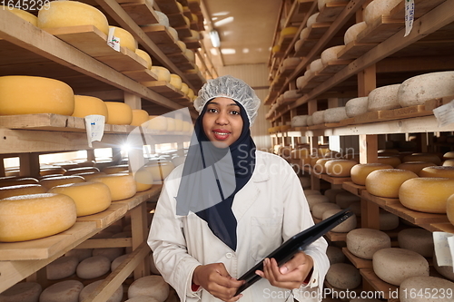 Image of African black muslim business woman in local cheese production company