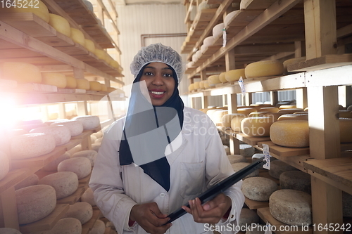 Image of African black muslim business woman in local cheese production company