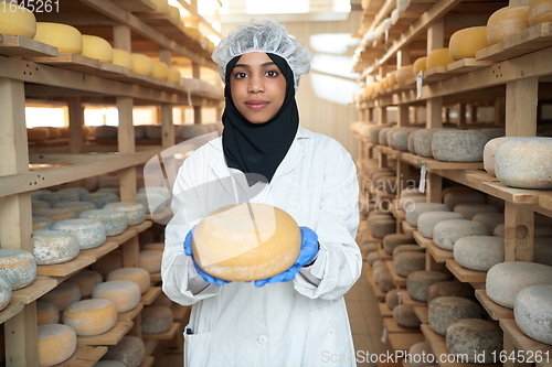 Image of African black muslim business woman in local cheese production company