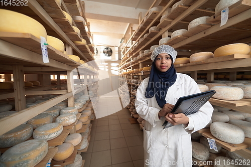 Image of African black muslim business woman in local cheese production company