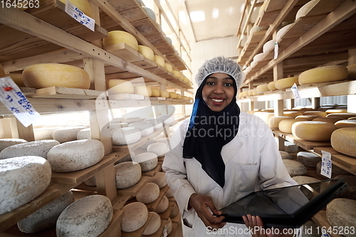 Image of African black muslim business woman in local cheese production company