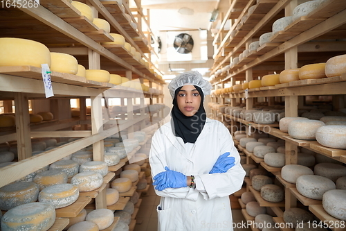 Image of African black muslim business woman in local cheese production company