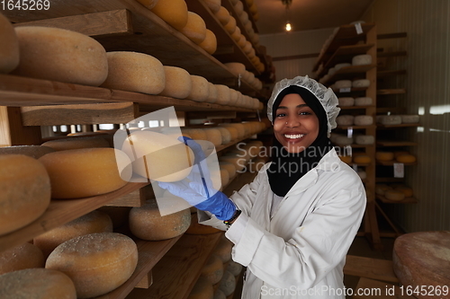 Image of African black muslim business woman in local cheese production company