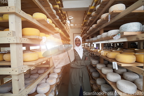 Image of African black muslim business woman in local cheese production company