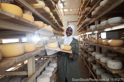 Image of African black muslim business woman in local cheese production company