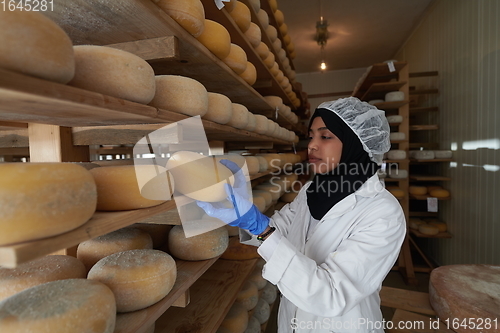 Image of African black muslim business woman in local cheese production company