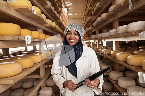 Image of African black muslim business woman in local cheese production company