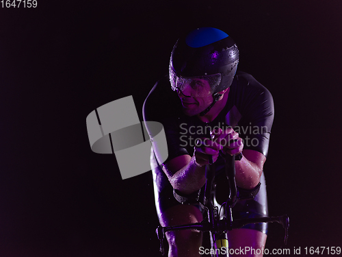 Image of triathlon athlete riding bike at night