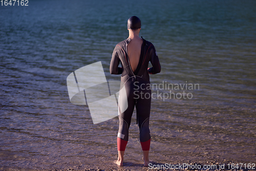 Image of triathlete swimmer portrait wearing wetsuit on training