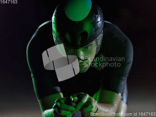 Image of triathlon athlete riding bike at night