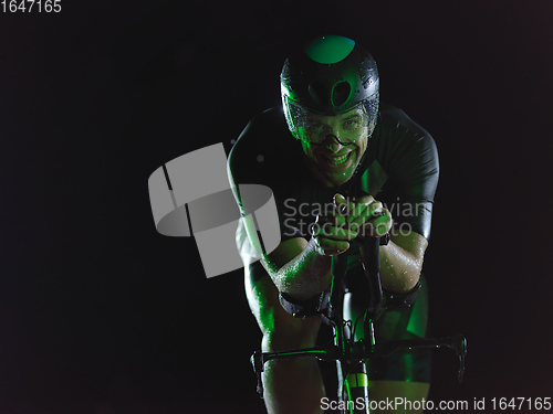 Image of triathlon athlete riding bike at night