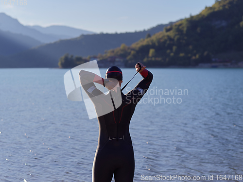 Image of triathlete swimmer portrait wearing wetsuit on training