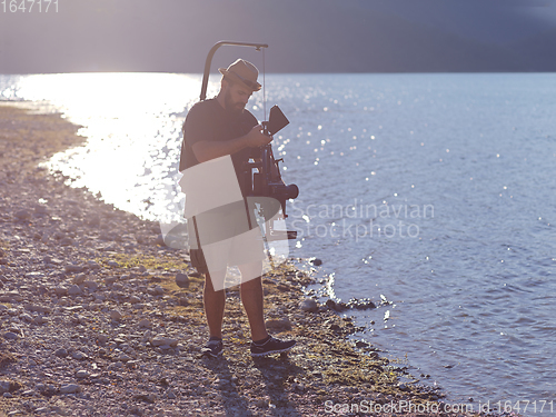 Image of videographer taking action shot of triathlon swimming athlete