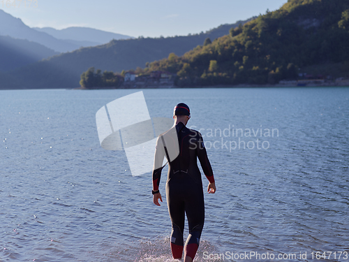 Image of triathlete swimmer portrait wearing wetsuit on training