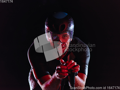 Image of triathlon athlete riding bike at night