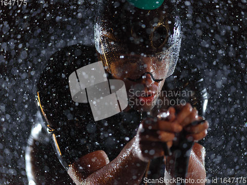 Image of triathlon athlete riding bike on rainy night