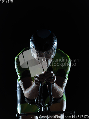 Image of triathlon athlete riding bike on rainy night