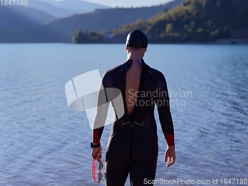 Image of triathlete swimmer portrait wearing wetsuit on training